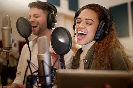 Artists, singer or people on studio microphone, music app or live streaming lyrics in song recording. Singing, musicians or friends on technology production, voice media or sound performance practiceの写真素材