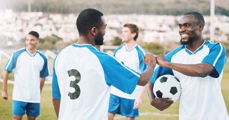 Fist bump, soccer team and fitness teamwork success of a sports group in training on a grass field. Football friends, support and exercise support with motivation outdoor for health workout and smileの写真素材