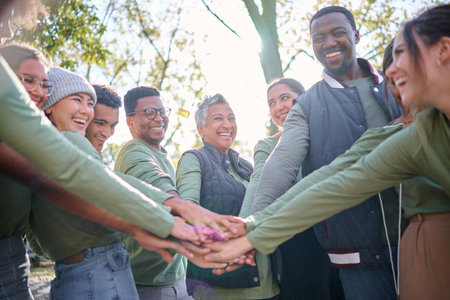 Team, motivation and friends in a huddle while hiking together in the forest or woods from below. Fitness, exercise or nature with a diversity man and woman friend group putting hands in a circleの写真素材
