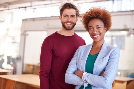 Tough times dont last, tough people do. Portrait of two coworkers standing in an office.の写真素材