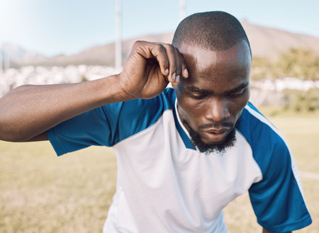 Black man is tired, face and football player on outdoor field, playing game or soccer training with...