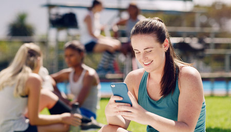 Woman, sports field and texting with phone, social media and communication for online dating, happy...