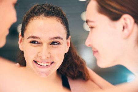 Happy, conversation and girl with friends at waterpolo training, fitness and smile at sports. Communication, face and group of athlete people at practice for sport, talking and laughing togetherの写真素材