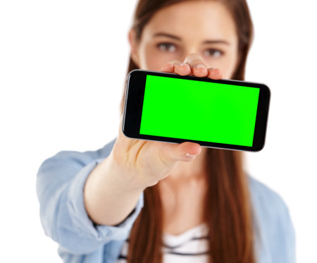I have a new app to show you. A young woman holding a mobile phone with green screen copyspace.の写真素材