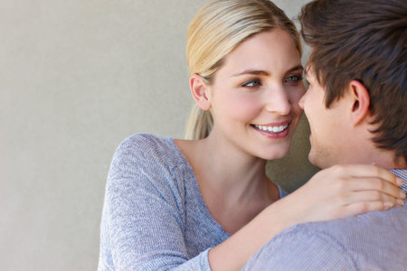 I love falling in love with you. an affectionate young couple standing against a gray background.