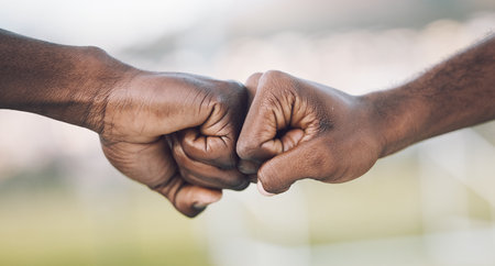 Fist bump, closeup and hands celebrating as teamwork on sports field winning and power of working together. Team, support and unity of teammates in collaboration or partnership with motivationの写真素材