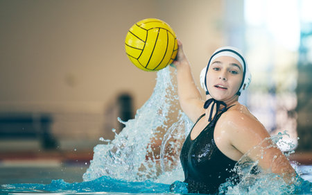 Water polo, cardio and portrait of a woman with a ball for a competition, game and training. Fitness, strong and athlete girl throwing with power, action and playing during a professional matchの写真素材