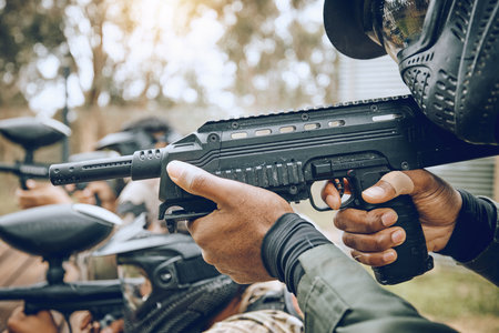 Paintball, gun and target with team, action and sports outdoor, people on battlefield and soldier focus during war game. Extreme sport, aim and military mission, exercise and fitness with motion blurの写真素材