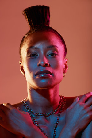 Portrait, face and makeup with a model black woman in studio on a neon background for beauty. Art, kaleidoscope and style with an attractive young female posing indoor for culture or cosmeticsの写真素材
