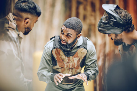 Paintball team, men and sports game while planning and talking strategy for action plan. Diversity people together with military, soldier or army leader person for war idea in outdoor battlefieldの写真素材