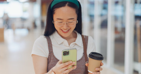 Digital marketing woman, smile and phone in workplace, social network or chat at communication startup. Asian corporate executive, smartphone or happy for app, web or social media marketing in Tokyoの写真素材