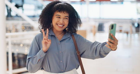Black woman influencer, selfie and peace sign with smile, smartphone or walking in urban shopping mall. Happy, phone and woman with hand gesture for social media, web or online app at mall in Atlantaの写真素材