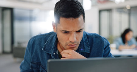 Thinking, confused and man at laptop writing notes for project planning at web design company. Professional ux employee at office working, thoughtful and focused on email idea for client.の写真素材