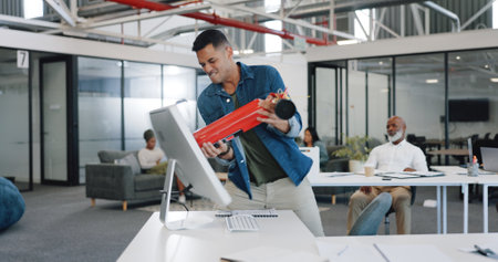 Anger, frustrated and fire extinguisher with a business man breaking a computer during a breakdown at work. Compliance, glitch and 404 with an angry male employee smashing a desktop in the officeの写真素材