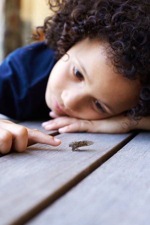 Boys, bugs and boredom. a bored little boy playing with an insect.