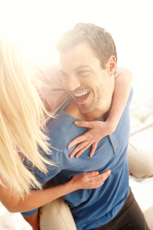 Fun-loving relationship. A man giving his girlfriend a piggyback ride and having fun.の写真素材