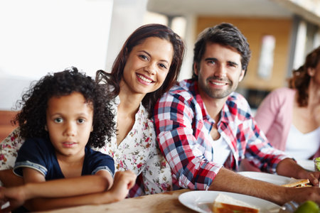 Lunchtime together helps us bond. A happy family enjoying a meal time together.の写真素材