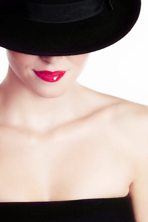 Hot lips. Beauty shot of a young woman wearing a hat and red lipstick.