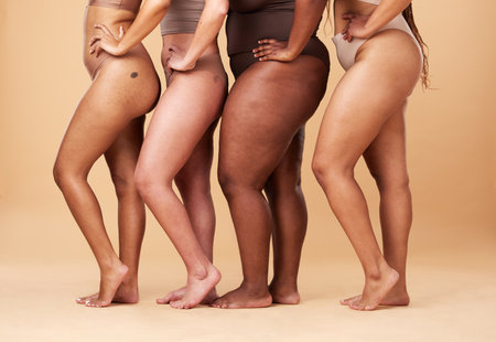 Diversity women, legs and different body and skin of group together for inclusion, beauty and power. Underwear model people on beige background with cellulite, pride and motivation for self loveの写真素材