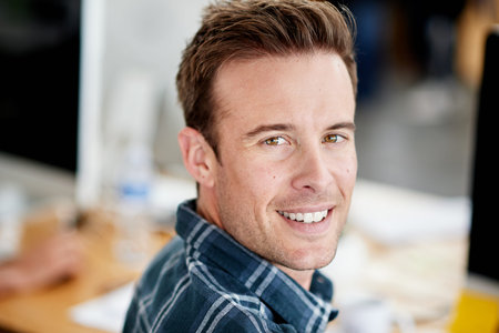 Be awesome today. Portrait of a designer sitting at his desk in an office.