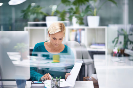 Productivity is at a high. A beautiful young businesswoman at work in her office.の写真素材