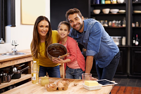 Wanna taste. Portrait of a happy family baking together in the kitchen.