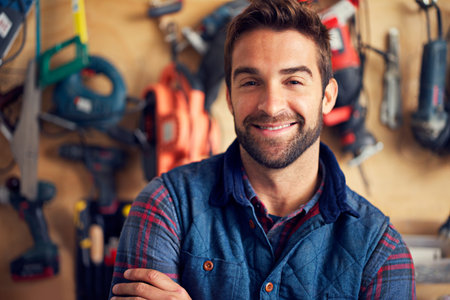 What can I repair for you today. Portrait of a handsome young handyman standing in front of his work...
