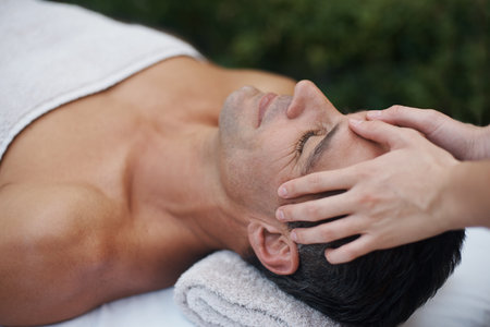 Calm mind healthy body. a handsome man enjoying a massage at a health spa.の写真素材
