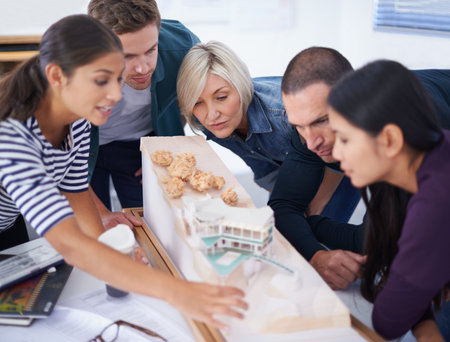 Everyone gave good input toward the design. a diverse group of people viewing a scale model.