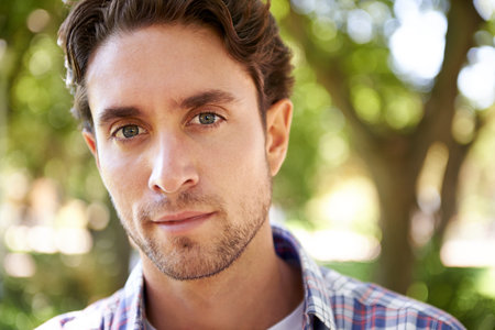Portrait, man and in park to relax, sunshine and happiness on weekend break, calm and peaceful....