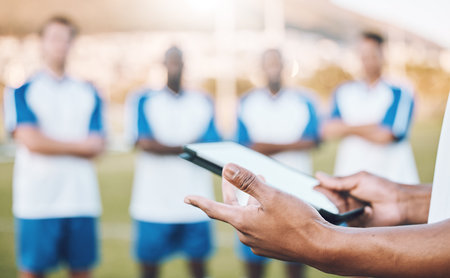 Football, soccer and team statistics on a tablet and coach analysis online, internet or website on a sports field. Teamwork, digital and tactics by modern trainer tracking performance analyticsの写真素材