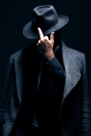 Mystery, middle finger or dark man in stylish outfit, fashion or suit posing isolated against a...