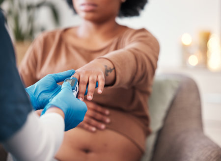 Pulse device on finger, pregnant woman and doctor checkup for blood oxygen level measurement. Medical professional testing in hospital, healthcare for pregnancy or nurse consulting african motherの写真素材