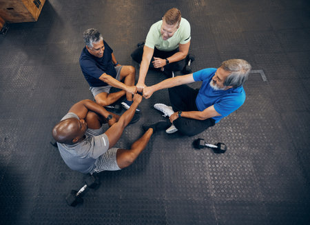 Team, fitness and teamwork by senior men exercise, workout and training together at the gym. Group, collaboration and hands in a huddle for diversity, support and trust together by elderly peopleの写真素材