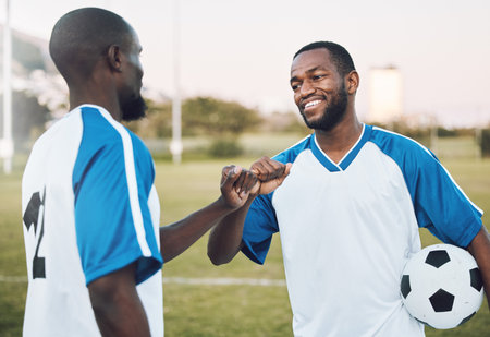 Fist bump, soccer ball and black man with teamwork success of sports training on a grass field. Football friends, support and exercise with fitness motivation outdoor for health workout and smileの写真素材