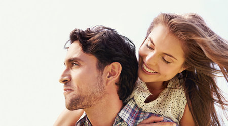 Couple, smile or piggyback on love, valentines day or romance date in park bonding, garden or nature. Happy, man and carrying woman in fun game, freedom security or energy support on sky backgroundの写真素材