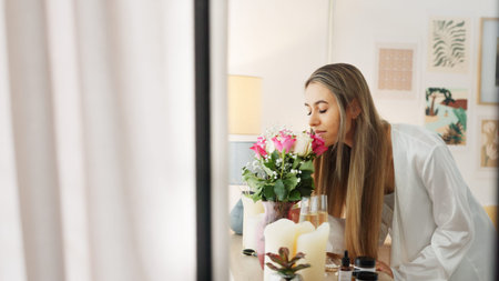 Smelling flowers, beautiful woman and beauty routine of a happy bride wearing a bathrobe while...