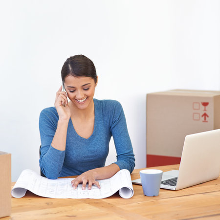 Im liking the office plans. A young woman talking on the phone while sitting in her office...