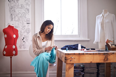 Working on her next line. a young fashion designer working on some sketches.の写真素材