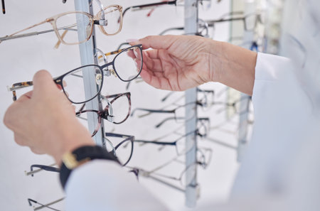 Working, decision and hands of an optometrist with glasses, eyewear and frame for vision in a shop....