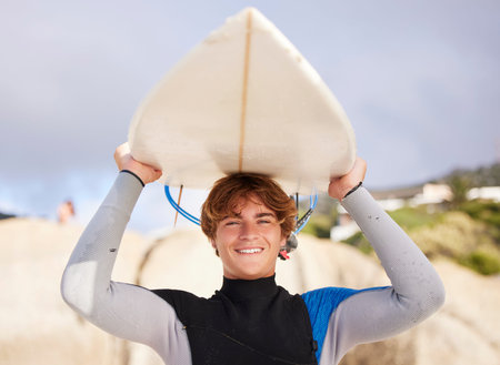 Beach, surfing and portrait of a man with a board for start of summer, fitness and relaxation. Exercise, smile and young surfer ready for training at the sea in the ocean on a holiday in Thailandの写真素材