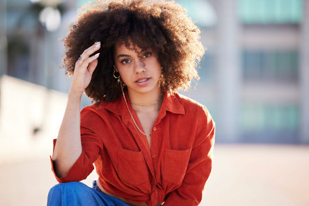Portrait of black woman with afro, urban and fashion for trendy gen z style and attitude in summer weekend. Beauty, city lifestyle and funky girl with serious face and hip hop streetwear in Brazil.の写真素材