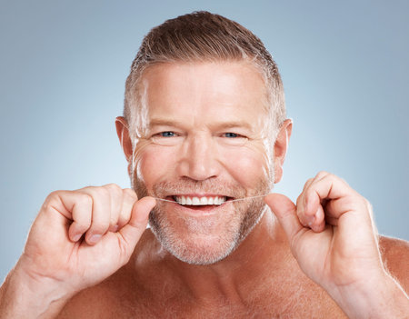 Floss, portrait and man with dental health for fresh breath, hygiene and cleaning teeth against blue...