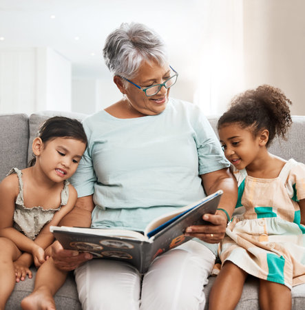 Family, grandmother and children with book reading on sofa for bonding, relaxing and quality time...