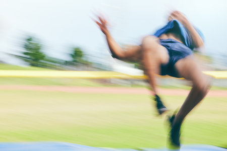 High jump, fitness and athletics by man at a stadium for training, energy and cardio against sky background. Jumping, athlete and male outdoors for performance, endurance and competition on mock upの写真素材
