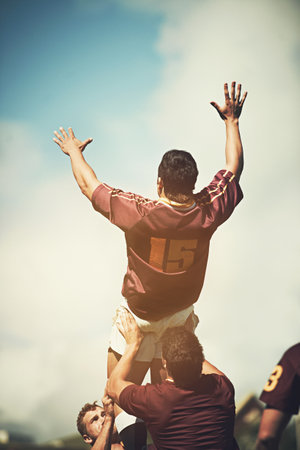 Throwing a dummy during the lineout. Rearview shot of a young rugby player jumping during a lineout.の写真素材