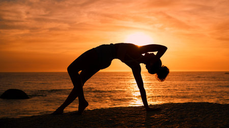 Balance, yoga and silhouette of woman on beach at sunrise for exercise, training and pilates workout. Fitness, meditation and shadow of girl by ocean for sports, wellness and stretching in morningの写真素材