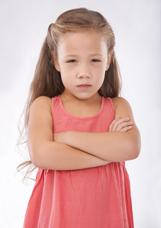 Im really not impressed. Studio portrait of a cross-looking young girl.