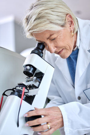 Doctor woman, ophthalmology and microscope for glasses tools to check and zoom on lens. Medical person at work for science, vision and health insurance working in lab, store or clinic for eye careの写真素材