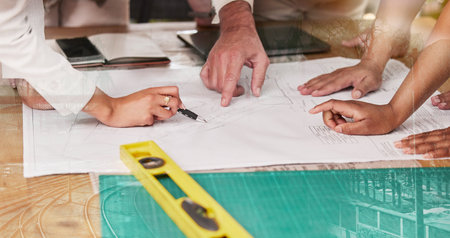 Hands, blueprint and architecture with a design team planning on a table using a floor plan....